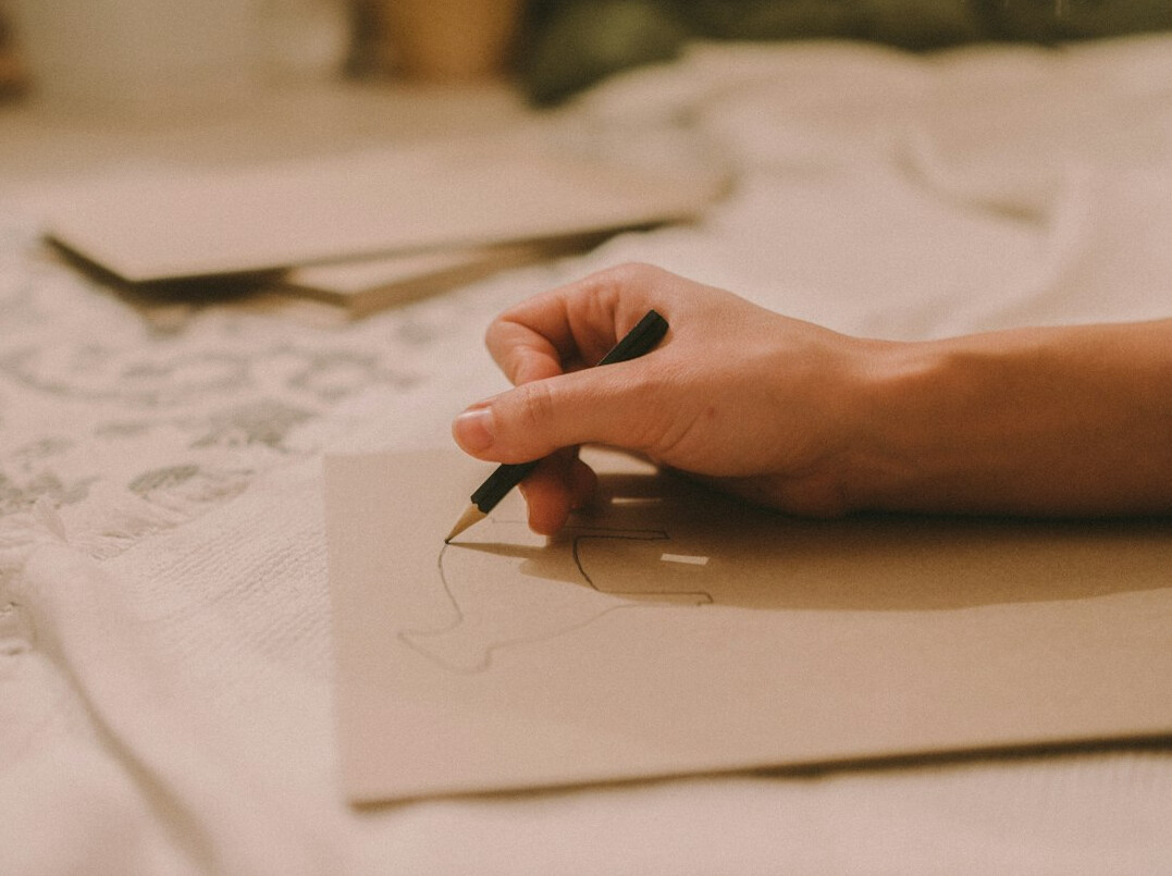 person writing letter by hand