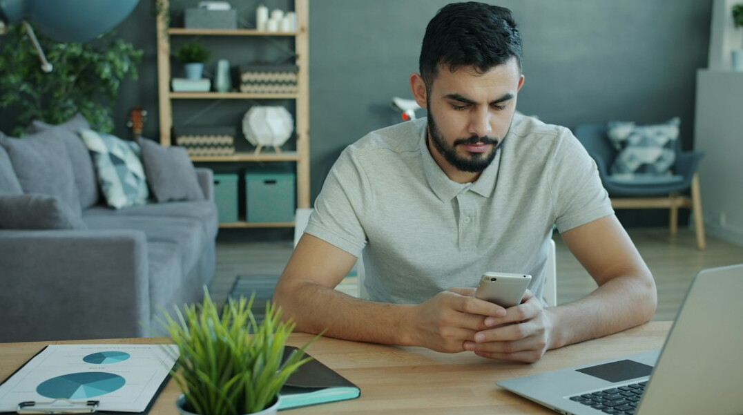 person using smartphone at desk