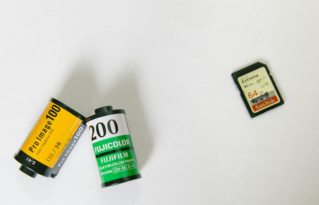 Rolls of film and a vintage camera on a wooden table